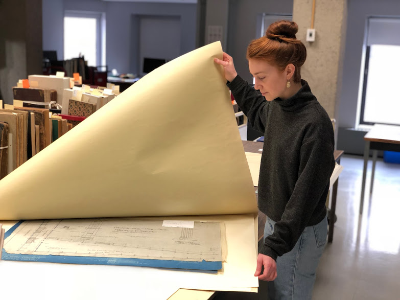 Heather Rogers looking at architectural plans in the digitization lab as a part of her practicum.