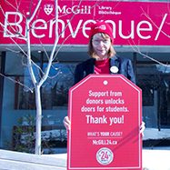 Dean Colleen Cook wearing a red McGill24 hat, holding a red McGill24 poster.