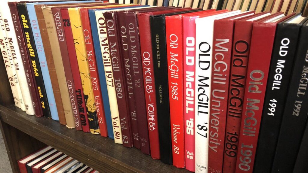 Many Old McGill yearbooks on a book truck.