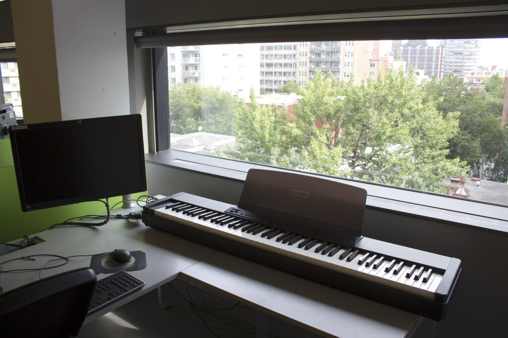 Keyboard and computer in front of a window in the Music Library.