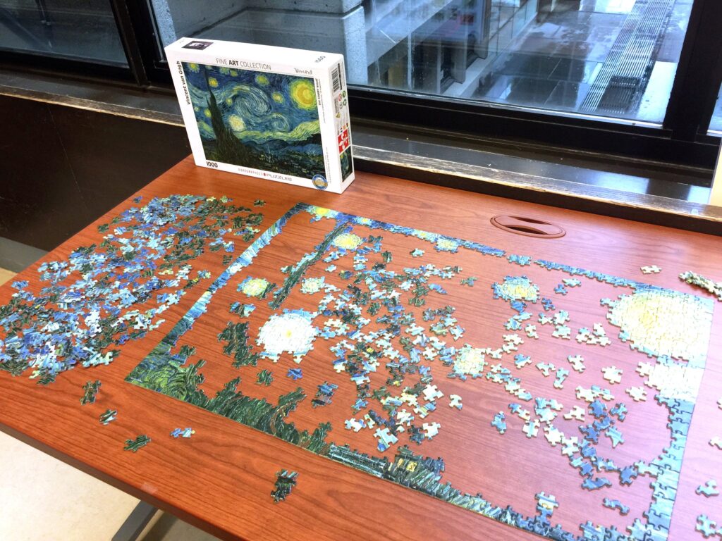 Partially completed puzzle on a wood table.