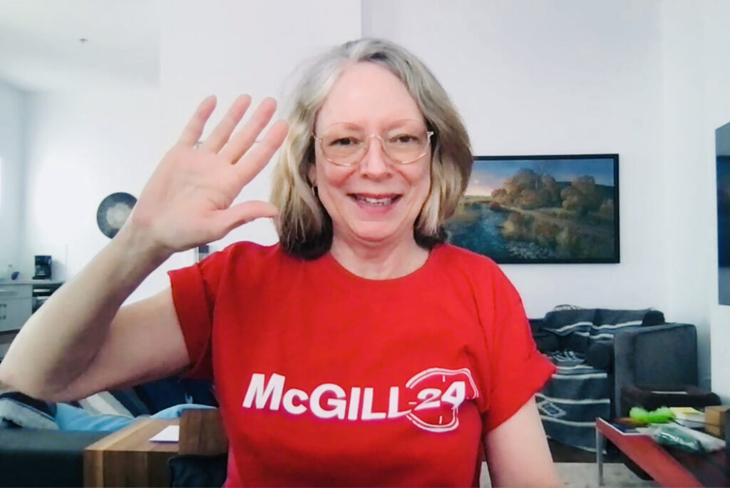 Dean Colleen Cook over Zoom smiling and waving in a Red McGill24 t-shirt.