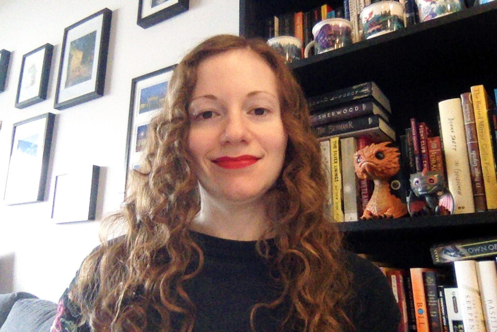 Sandy Hervieux in front of a bookshelf.