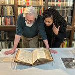 Paul Gross and Kimberley Rampersad leaning over a Rare Book.