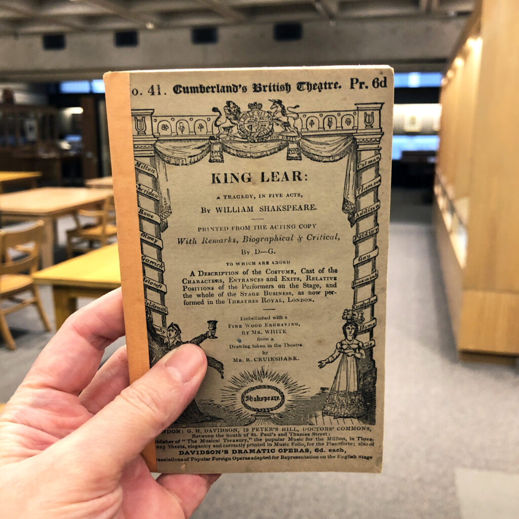 Hand holding up King Lear manuscript in Rare Books and Special Collections Reading Room.