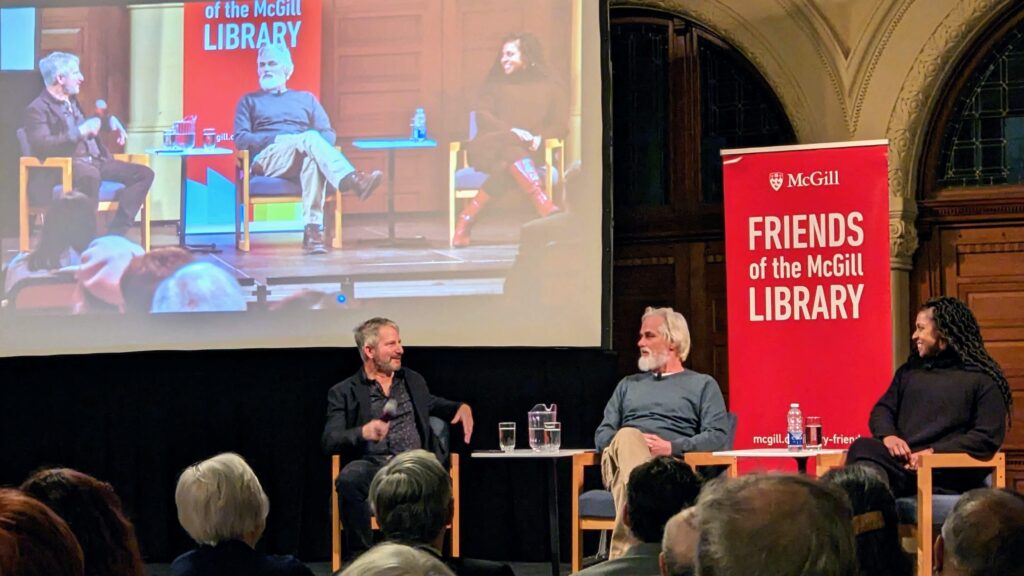 Photo from event featuring Paul Yachnin, Paul Gross and Kimberley Rampersad on stage with a red Friends of the Library banner behind them.