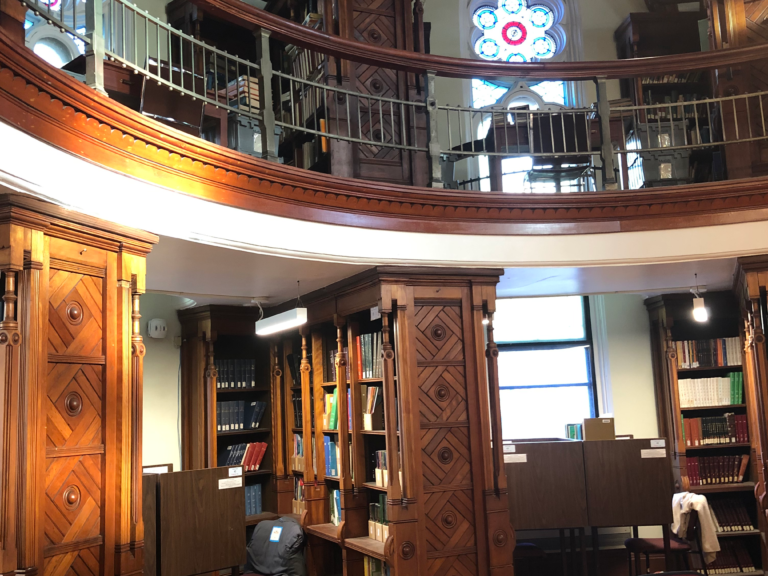 Islamic Studies Octagon Room featuring wood panels, bookshelves, and stained glass.