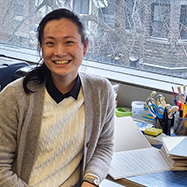Ariel Pan smiling at the camera sitting at a desk in the Marvin Duchow Music Library