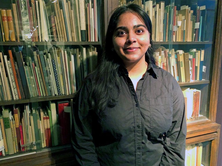 Mashall Hameed standing in front of a bookshelf.