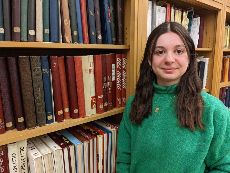 Maëlys Lemonnier smiling at the camera standing in front of a bookshelf.