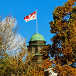 Flag on McGill Arts Building against blue sky