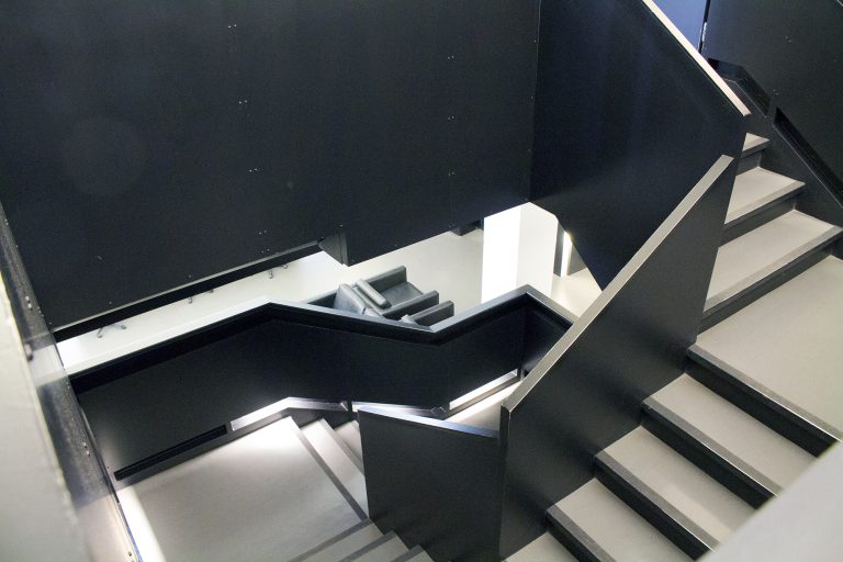 Winding staircase with black railings.