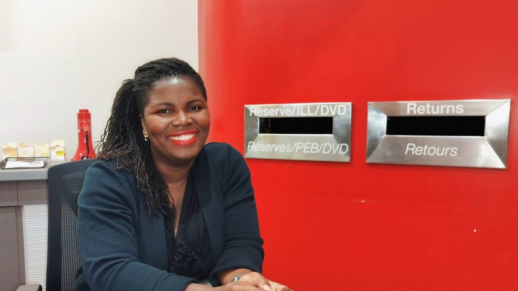 Deborah Ahenkorah at the reference desk located in the McLennan Library Building