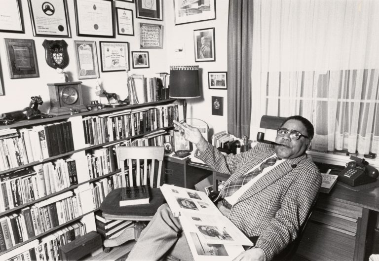 Black and white photo of Roy States seated in his office.