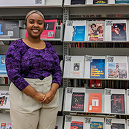 Tsion Sisaye in front of a book display