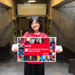 Student in a library holding up a colourful McGill24 poster.