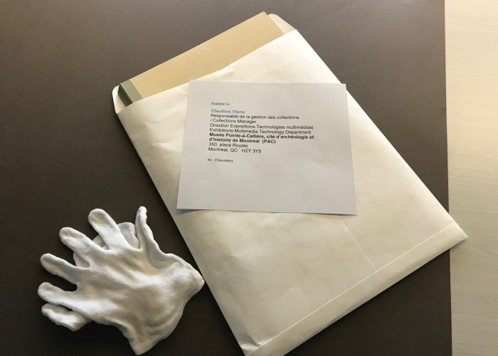 Folders and item descriptions are placed into envelope.
