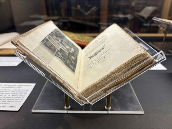 Rare book open in an exhibition case.